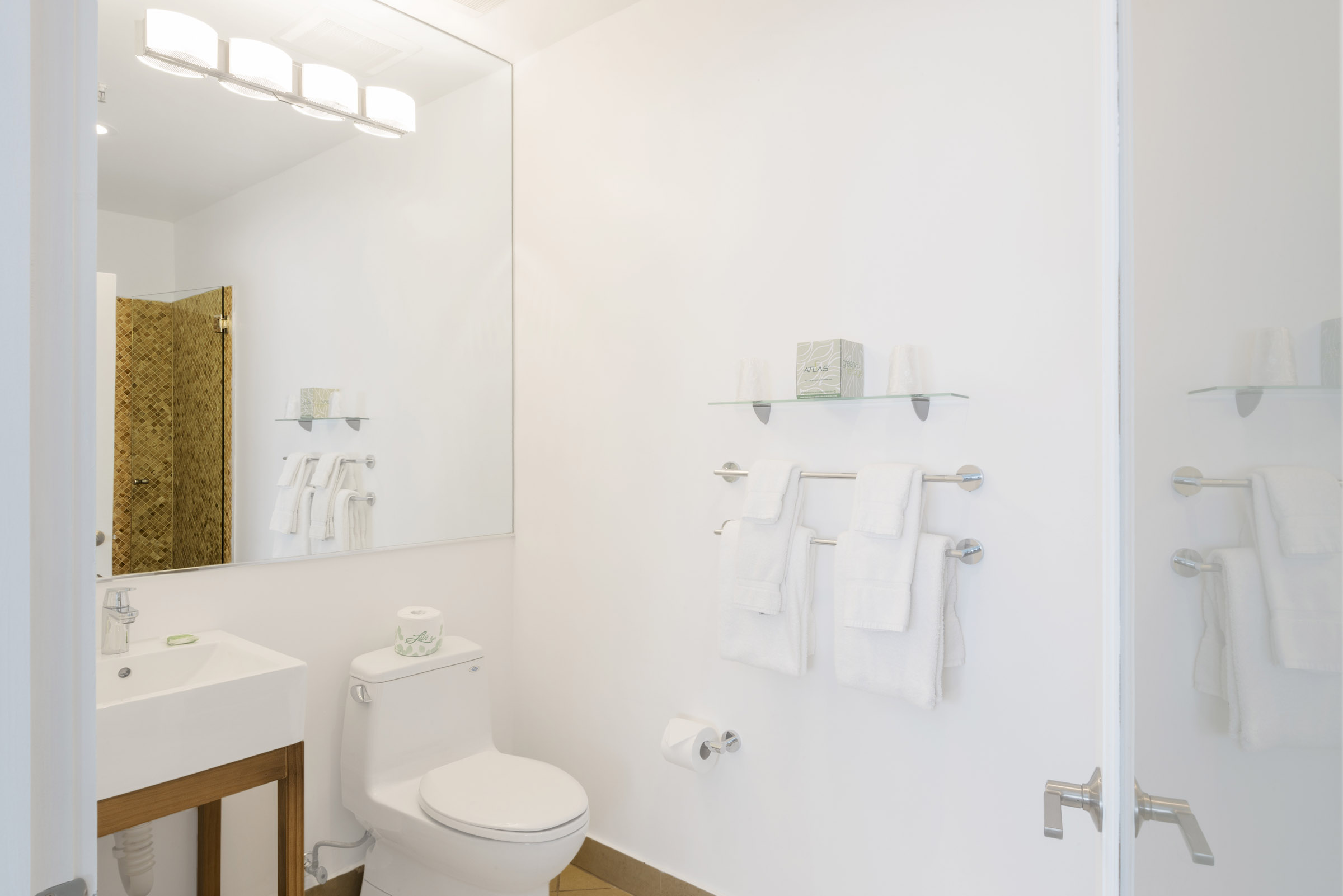 A clean and modern bathroom with a toilet, sink, and mirror